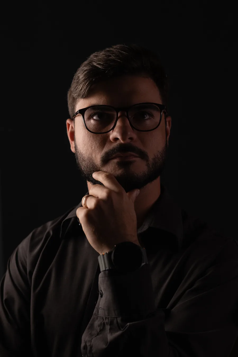 Guilherme Creimer em retrato de estúdio sobre fundo escuro.